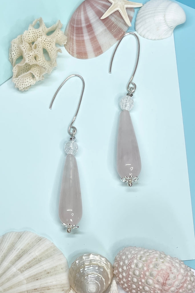 Approximately 6cm length. Drop style earrings. 925 silver hook earrings. Pale pink Rose quartz teardrop shaped stone with a single crackle rock crystal bead on top.