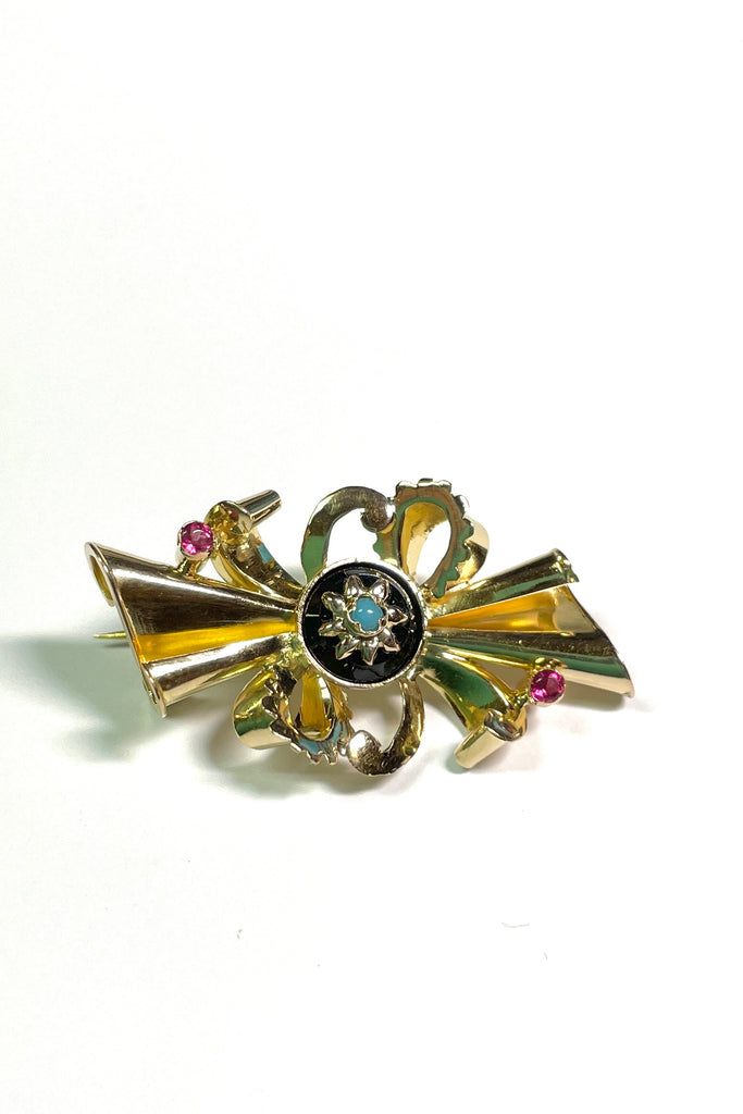 the brooch is unmarked gold with two tiny pink stones either pink garnet or ruby, the centre is black onyx with a star that has a turquoise centre stone.
