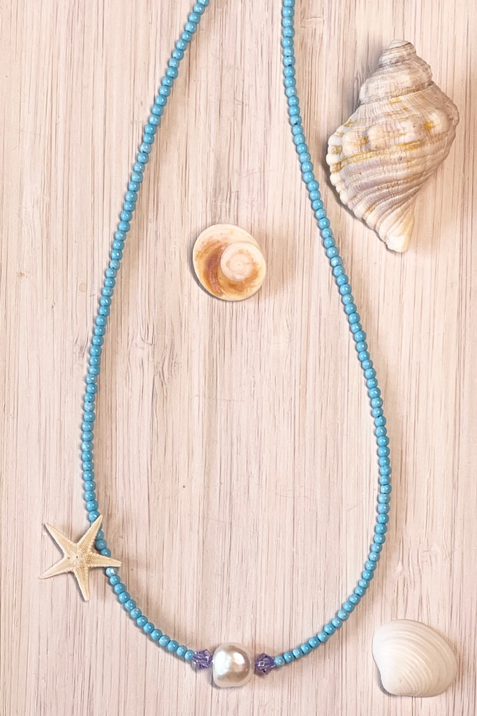 A delicate choker style necklace made with tiny sand seed beads, with a pearl and Swarovski crystal centre piece.