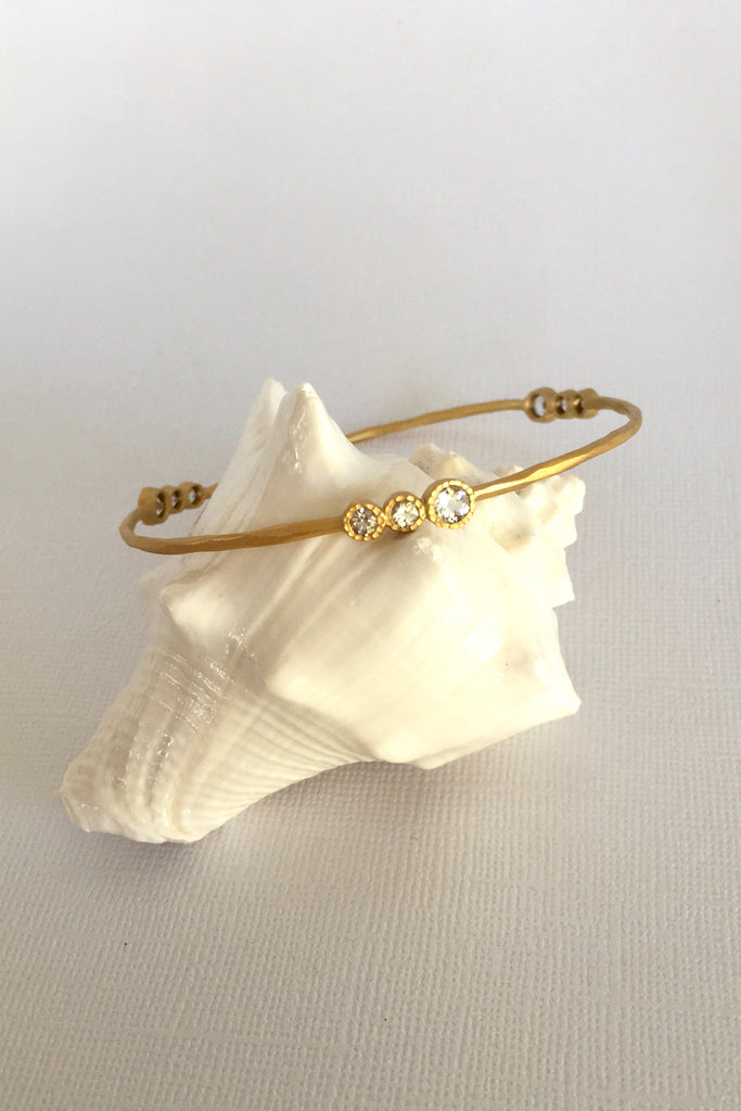 This adorable bangle has Starry luna appeal it is handcrafted in gold plated  silver vermeil. The gems are studded in sets of three and will sparkle at different angles