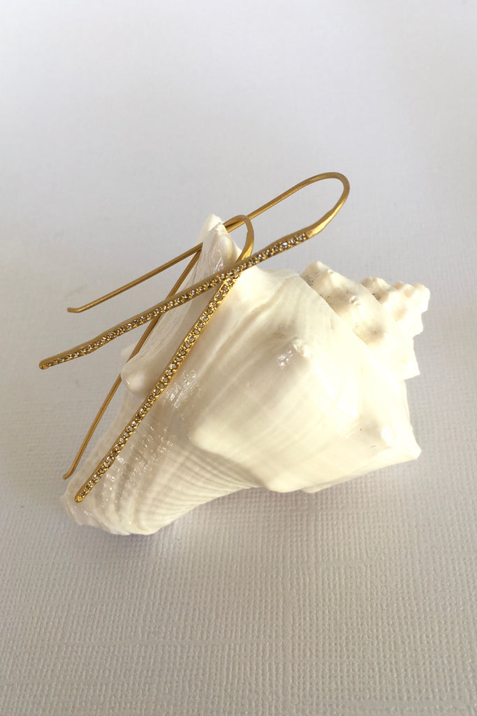 The name is Earth Moon, the style is inspired by tiny slivers of moonlight lighting the golden beach sand. Made in gold vermeil and tiny sparkling white topaz gemstones, the finish is quiet and naturalistic, the surface is matte. 