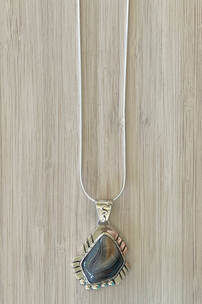 An intriguing powerful and reflecting stone pendant. A modernist pendant in a unique design, the blue Labradorite stone was cut and faceted by a local Sunshine Coast stone artist,