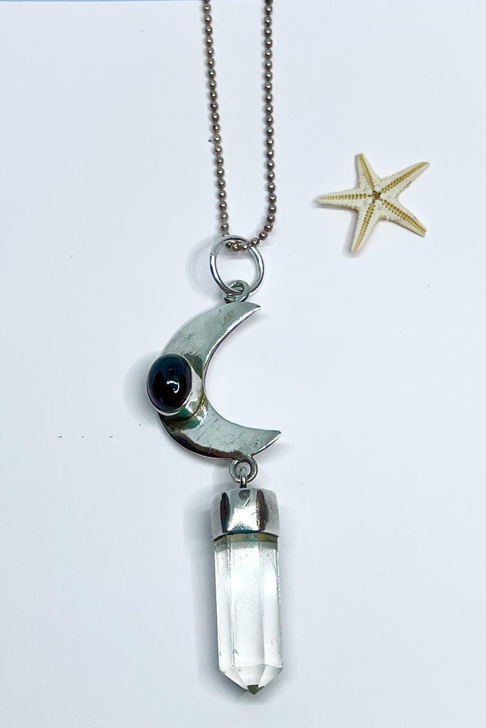 silver pendant with crystal point suspended and a garnet