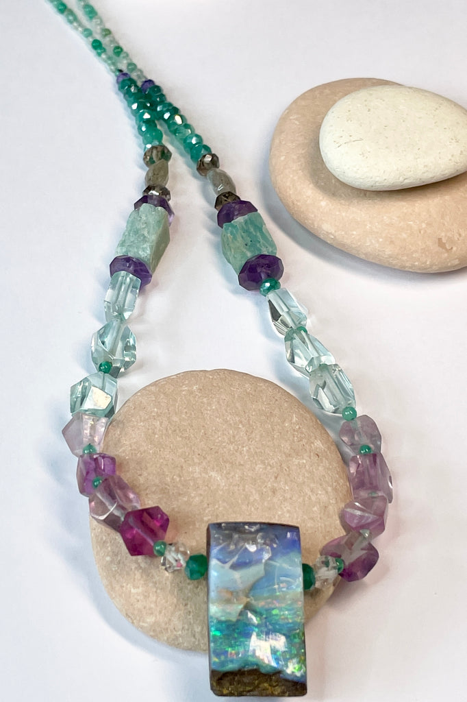 Opal necklace  The centrepiece is cut from an opal "split" so the surface is not polished but left exactly as it has been for millions of years. the back and sides are curved and polished to a soft shine. Bright flashes of crystal blue, green and mauve 