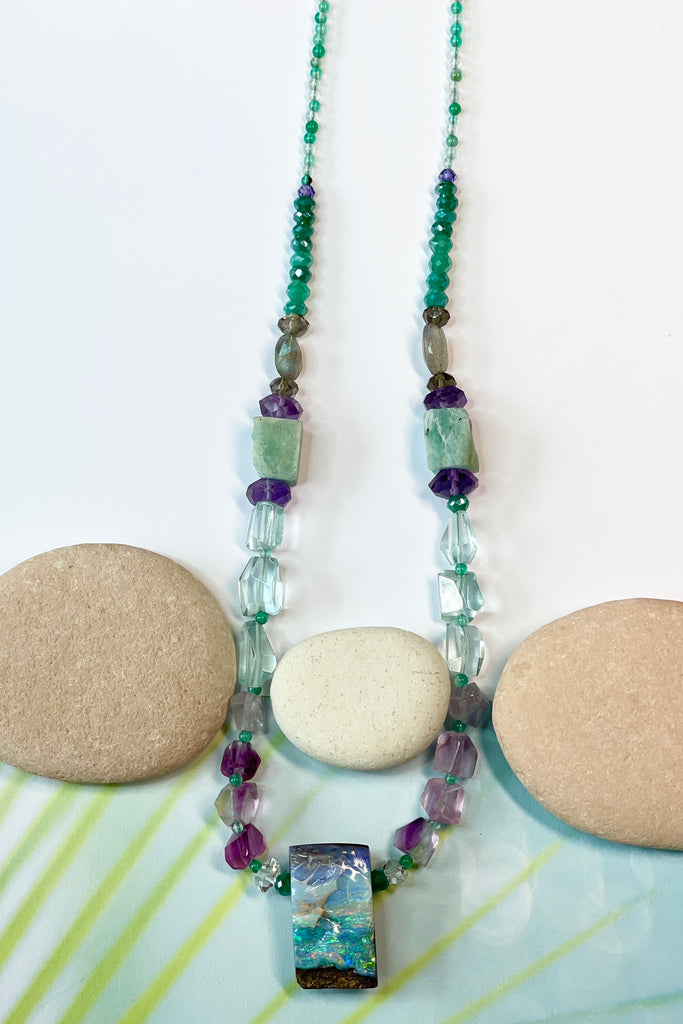 Opal necklace  The centrepiece is cut from an opal "split" so the surface is not polished but left exactly as it has been for millions of years. the back and sides are curved and polished to a soft shine. Bright flashes of crystal blue, green and mauve 