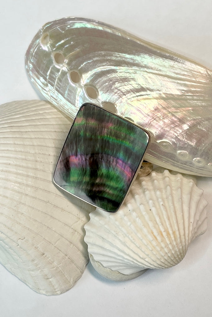 A really pretty luminescent silvery grey pink Mother of Pearl ring that catches the light in different directions. Ring is a 925 silver setting.  
