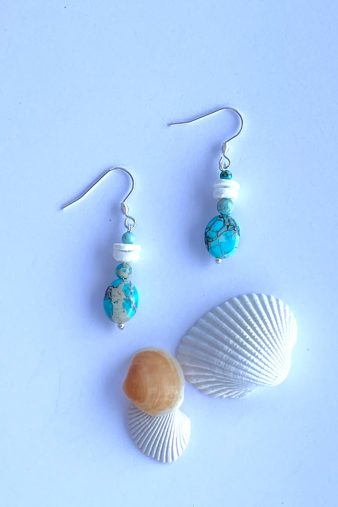 Tiny and pretty these earrings have a little turquoise howlite bead and hand cut shell beads.
