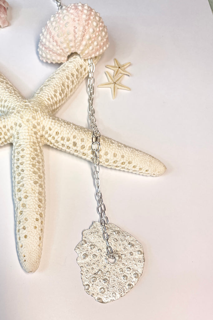 . The centre piece is silver, it is cast from a sea urchin shell. This pendant  is so delicate and has the feeling of a tiny sparkly shard floating in the ocean. 