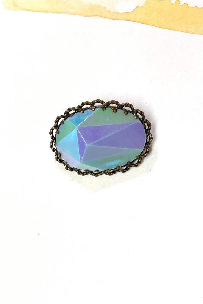 An old and unusual brooch, most likely from the 1930's. The blue is a coated glass the edge is metal
