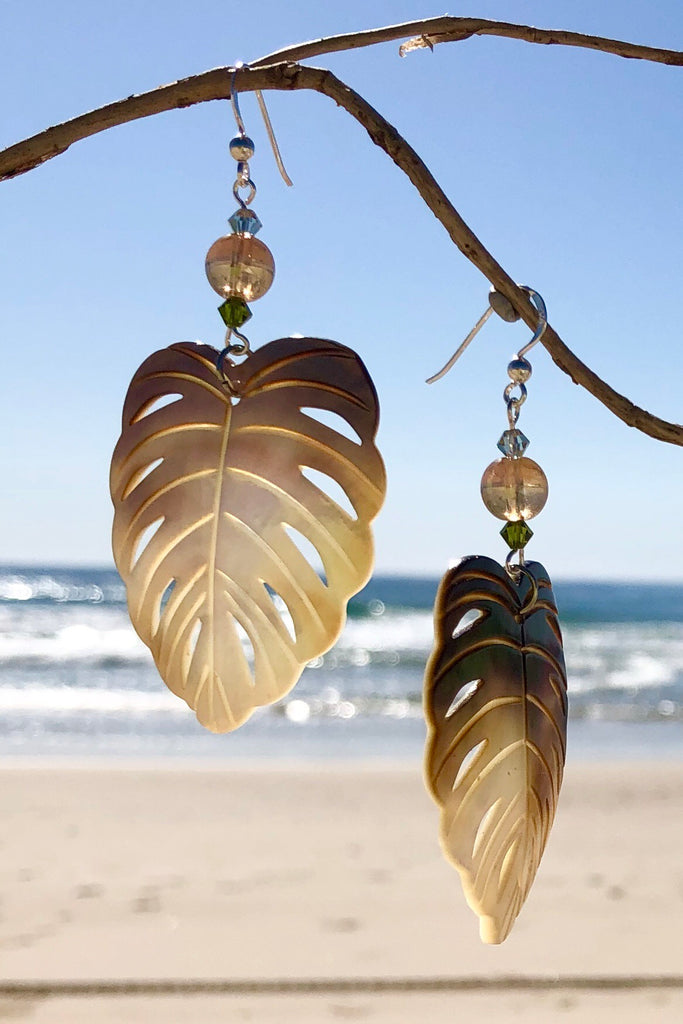 The gorgeous leaf in gold and silvery bronze Mother of Pearl has been hand cut and polished. At the top there is an iridescent crystal bead and a swarovski crystal bead. These earrings are made exclusively for Mombasa Rose