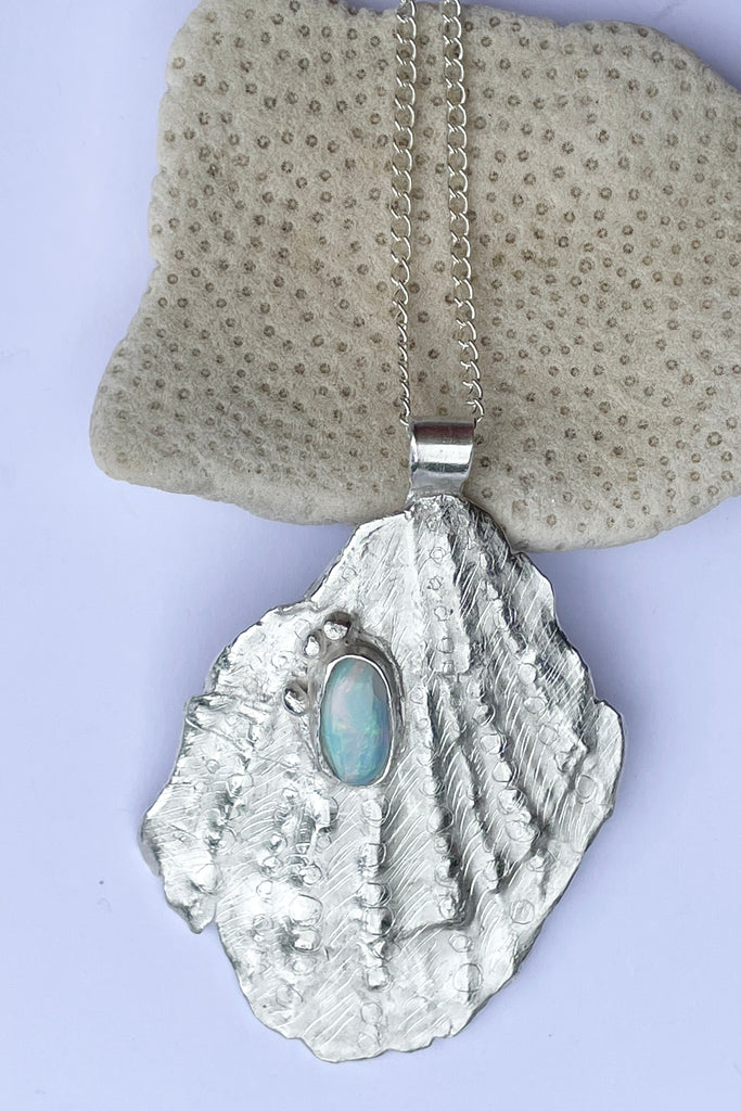 The pendant is solid silver, it is cast from an old sea worn shell and has a beautiful Australian opal set onto the front. This pendant is totally unique, it has the feeling of the spirit of the ocean