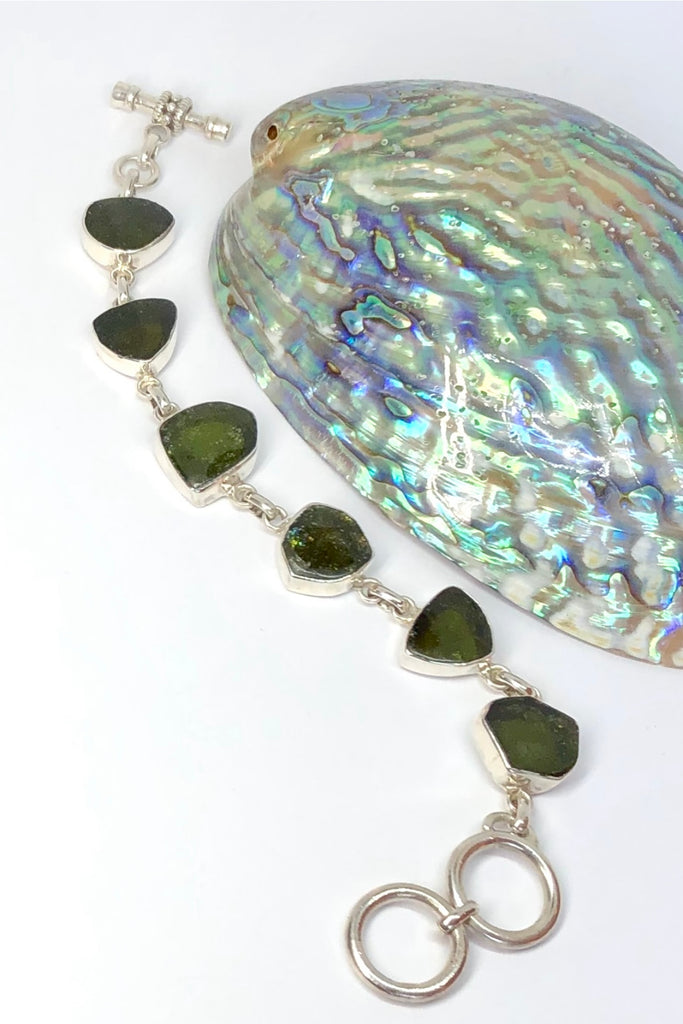 Echo Bracelet Tourmaline Green, each of the six stones has been individually set and rim set into 925 silver. The stones are all cut and polished into different shapes and linked in 925 silver.