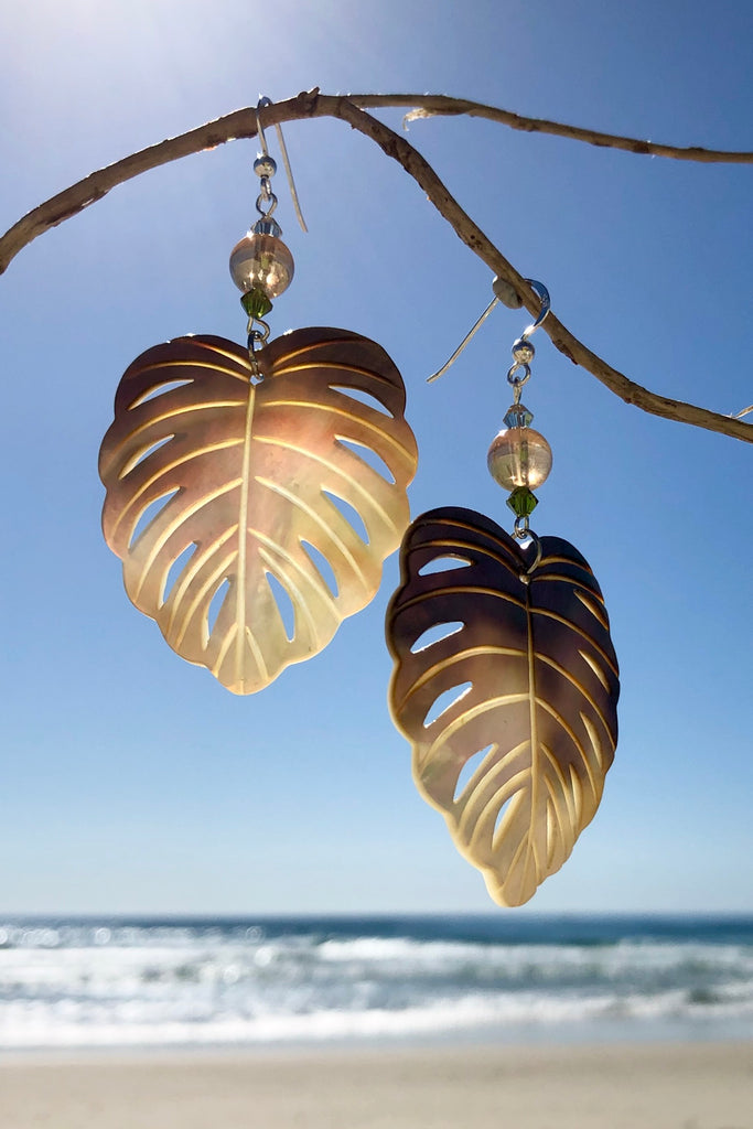 The gorgeous leaf in gold and silvery bronze Mother of Pearl has been hand cut and polished. At the top there is an iridescent crystal bead and a swarovski crystal bead. These earrings are made exclusively for Mombasa Rose