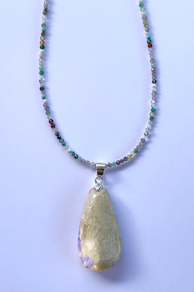 This opal is a one off piece, a hand cut and shaped light matrix opal, there is a lovely pale mauve crystal cave on one side, the top surface shows a mysterious bright green sparkle under sunlight.