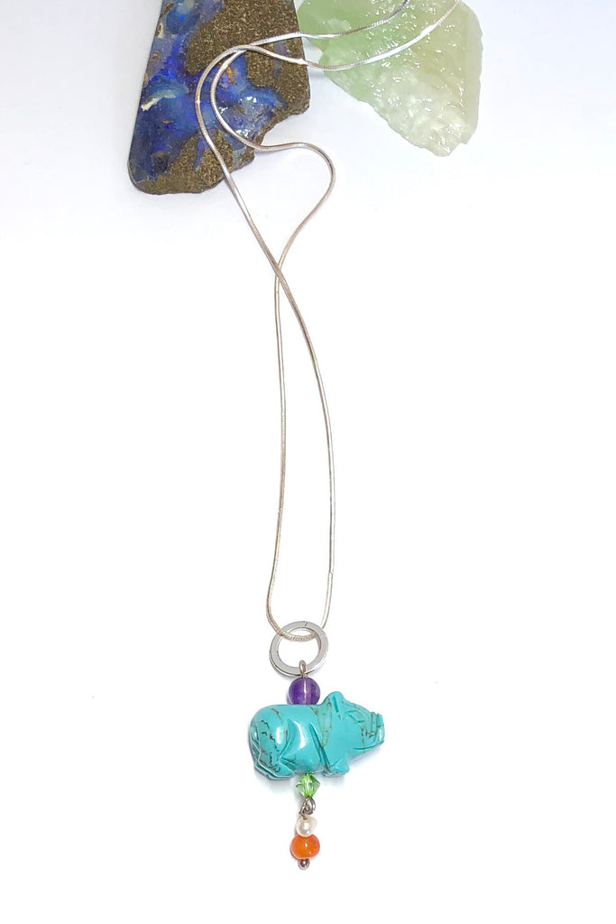 Pendant tiny Howlite Pig on Silver Chain features pig shape turquoise dyed Howlite gemstone with an amethyst top bead, Carnelian and pearl bead with a green crystal bead.