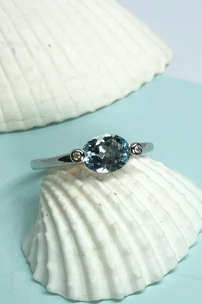 This ring gives a modern twist to antique styling. The lovely marquise cut and faceted Aquamarine is off set by two one point diamonds, one on each corner.