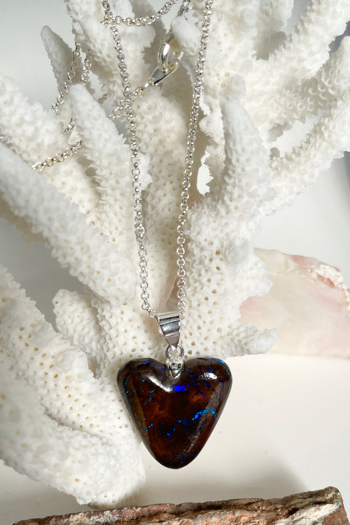 This intriguing and unique piece of opal was cut and polished into the heart shape for Mombasa Rose in Noosa, Queensland. The flashes of turquoise and teal go across and deep into the stone, giving it a flashing twinkling look. 