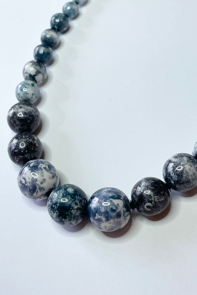 This unusual retro necklace is made with graduated white beads that have a blue grey marbled effect applied. Still on the original knotted cord, the condition is very good.