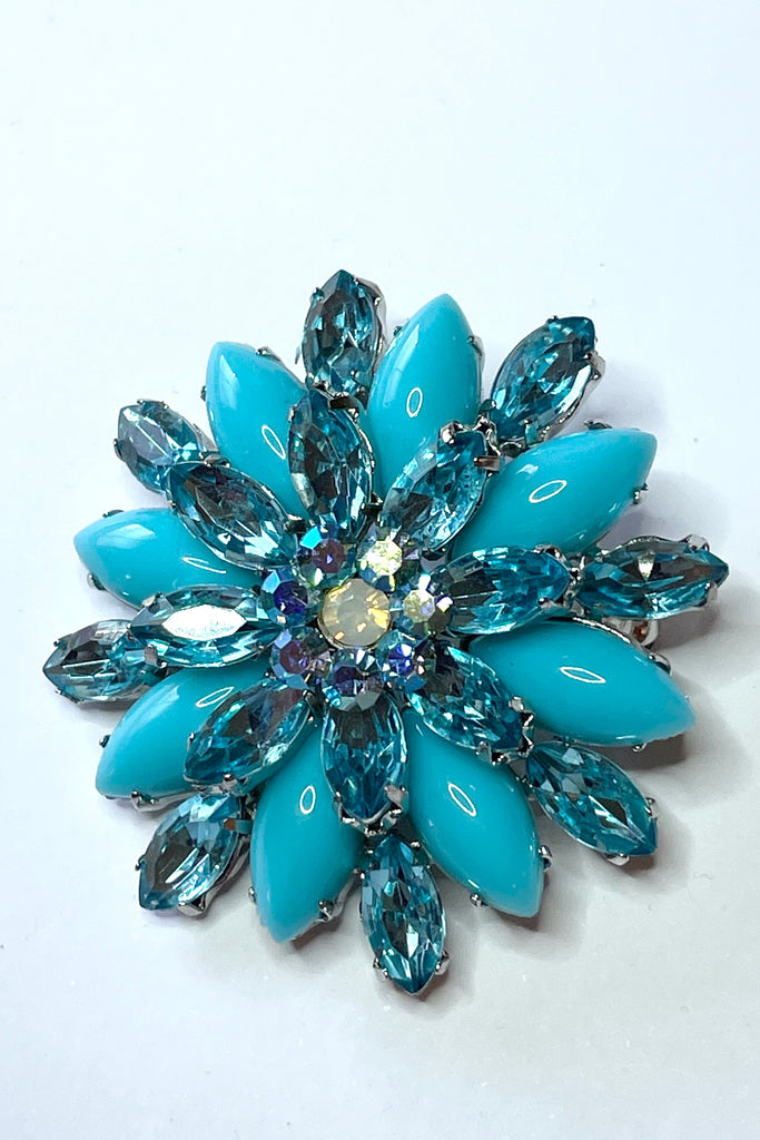 A sparkling and bright brooch from the 1980's. In the form of a bright turquoise flower with aqua diamante highlights. 