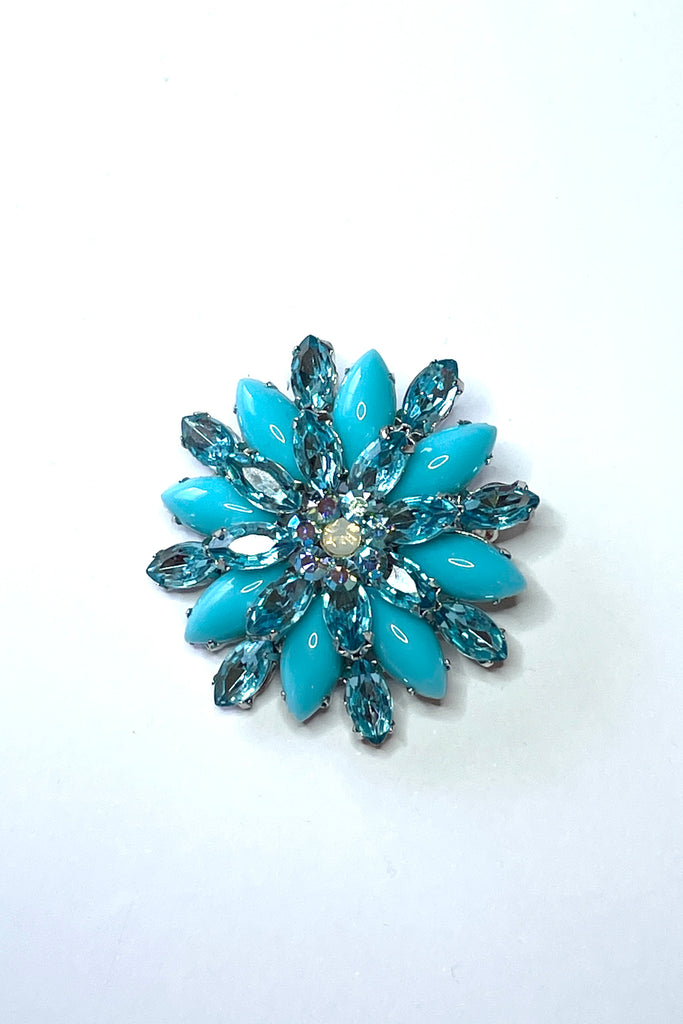 A sparkling and bright brooch from the 1980's. In the form of a bright turquoise flower with aqua diamante highlights. 
