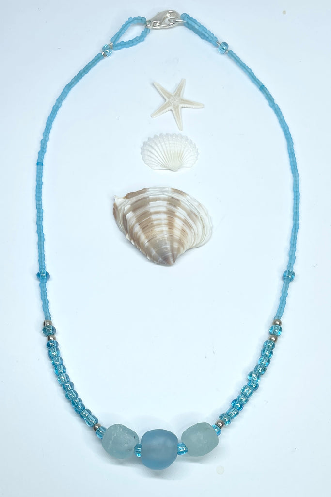 Add a little luster to your accessories with these luminescent  turquoise blue translucent Ghana glass seed beads in a clear marine colour, highlighted with three recycled frosted glass beads also from Ghana in Africa.