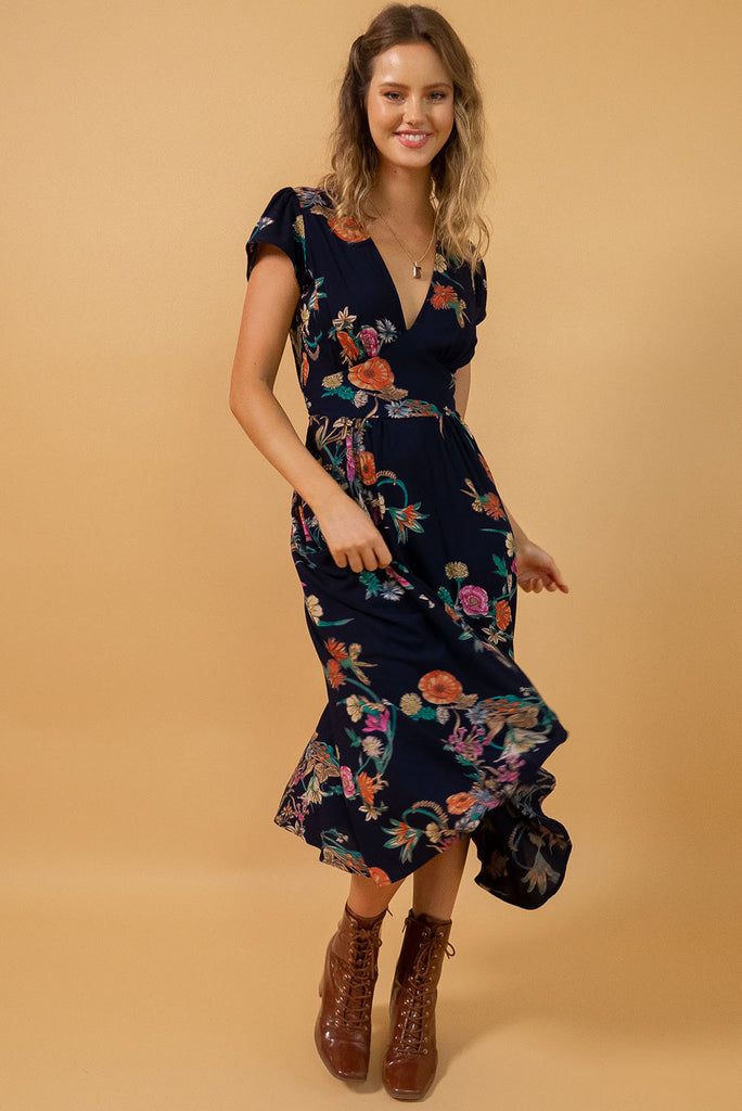 Lizzie Navy Bouquet Midi Dress features fitted elasticated waist, a cap sleeve and deep v neck and it comes in a dark navy with multicoloured floral design on a soft woven 100% rayon, perfect for vintage style lover.