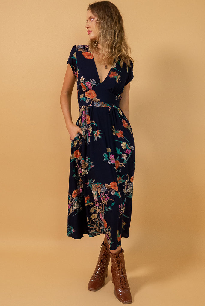 Lizzie Navy Bouquet Midi Dress features fitted elasticated waist, a cap sleeve and deep v neck and it comes in a dark navy with multicoloured floral design on a soft woven 100% rayon, perfect for vintage style lover.