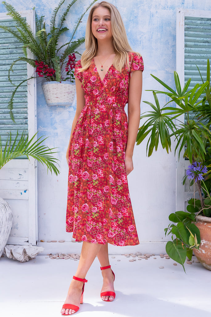 The Lizzie Rose Manor Midi Dress is a gorgeous hot pink based dress with an exclusively designed bohemian tile and overlapping rose print. The dress features cap sleeves, a deep v neckline, fitted Basque waist with gathered bust, elastic shirring at back waist, side pockets and is made from woven 100% rayon.