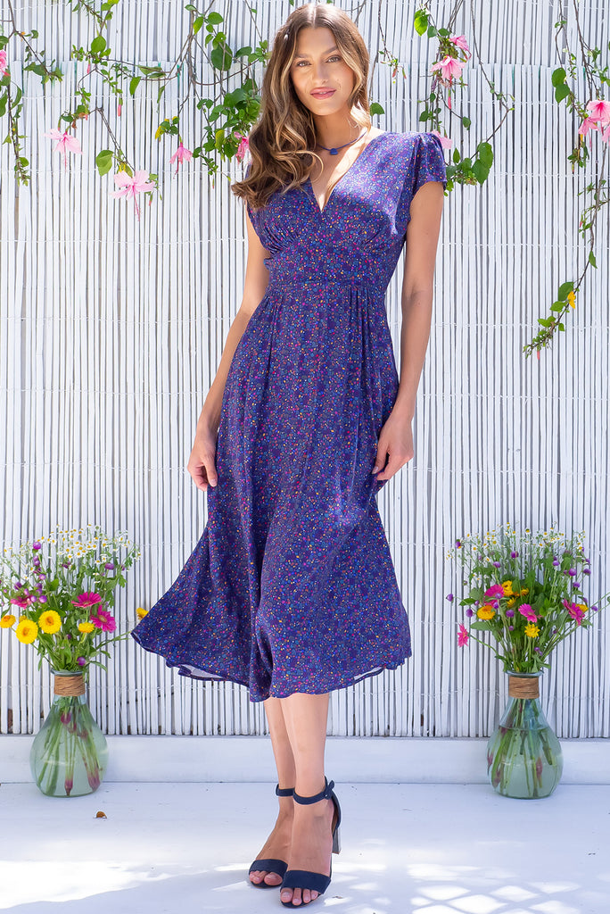The Lizzie Seashells Navy Midi Dress is a gorgeous navy based midi dress with a multicoloured ditzy seashell print. The dress features cap sleeves, a deep v neckline, fitted basque waist with gathered bust, elastic shirring at back waist, side pockets and is made from woven 100% rayon.