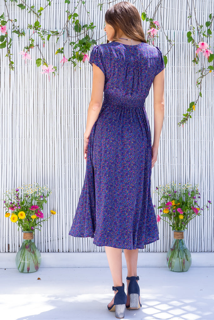The Lizzie Seashells Navy Midi Dress is a gorgeous navy based midi dress with a multicoloured ditzy seashell print. The dress features cap sleeves, a deep v neckline, fitted basque waist with gathered bust, elastic shirring at back waist, side pockets and is made from woven 100% rayon.