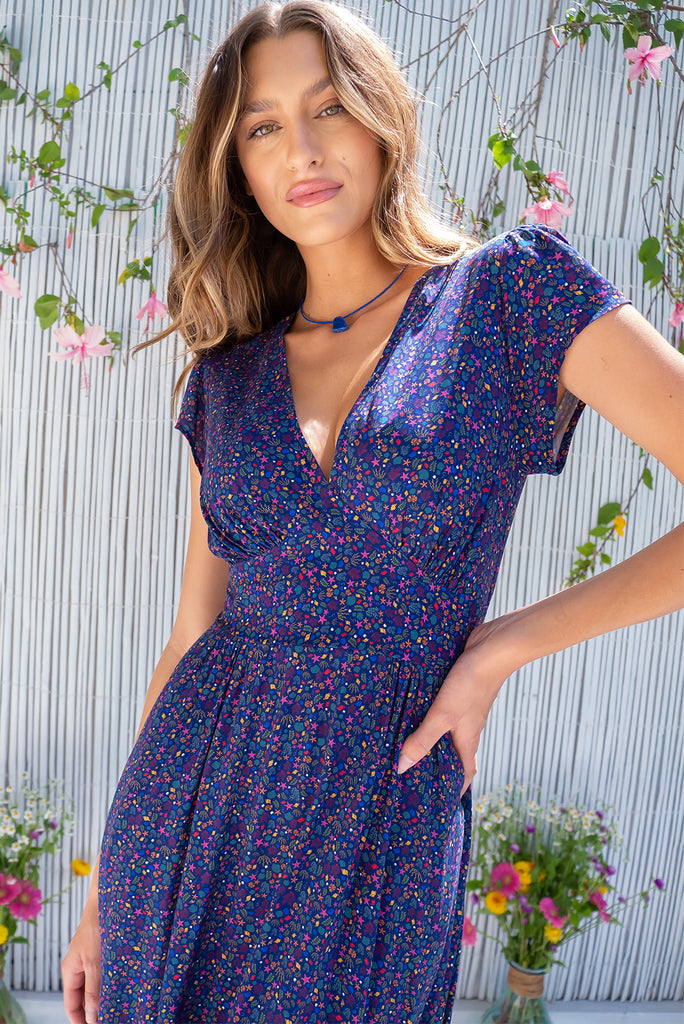 The Lizzie Seashells Navy Midi Dress is a gorgeous navy based midi dress with a multicoloured ditzy seashell print. The dress features cap sleeves, a deep v neckline, fitted basque waist with gathered bust, elastic shirring at back waist, side pockets and is made from woven 100% rayon.