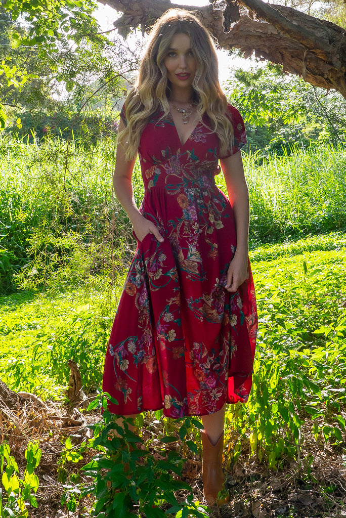 Lizzie Red Bouquet Midi dress features a vintage inspired fitted basque waist and elasticated waist with a cap sleeve and deep v neck the fabric is a soft woven rayon in a bright red bouquet floral print.