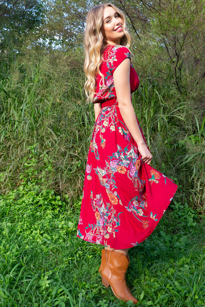 Lizzie Red Bouquet Midi dress features a vintage inspired fitted basque waist and elasticated waist with a cap sleeve and deep v neck the fabric is a soft woven rayon in a bright red bouquet floral print.