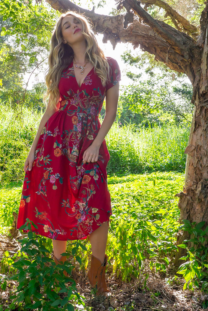 Lizzie Red Bouquet Midi dress features a vintage inspired fitted basque waist and elasticated waist with a cap sleeve and deep v neck the fabric is a soft woven rayon in a bright red bouquet floral print.