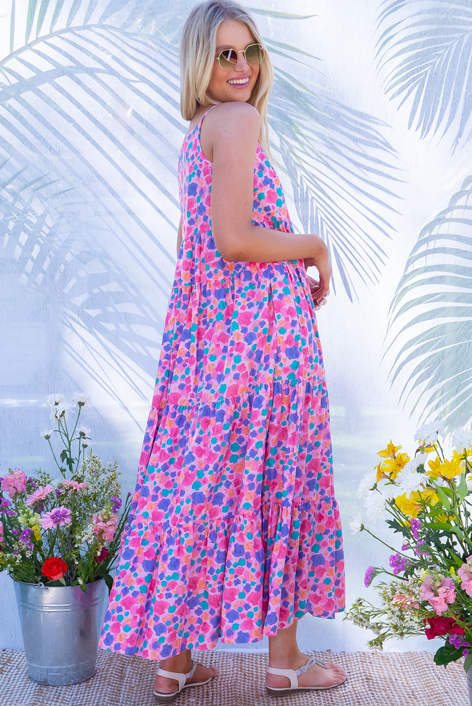 The Lulu Darling Sea Shells Pink Tiered Maxi Dress features a high neck with thin straps, high cut under arms, full tiered skirting from the bust down and deep side pockets. The pink based dress has a multicoloured seashell print all over in. Made from 100% cotton poplin.