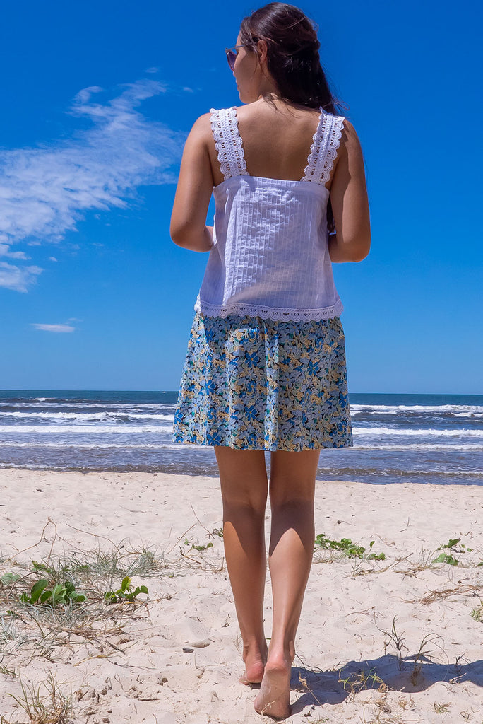 The Minnie Blue Note Mini Skirt is a beautiful teal mini skirt with a black base and blue floral print. The skirt is a comfortable slip-on style, a-line cut and features side pockets and an elasticated paper bag waistband. This mini skirt is woven 100% cotton.