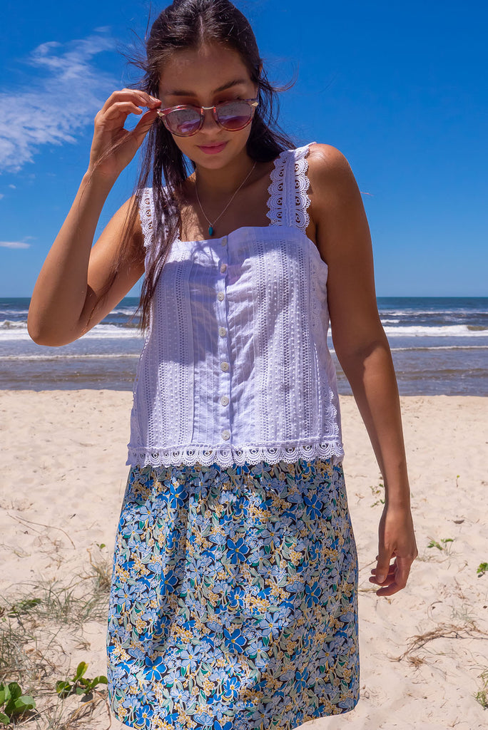The Minnie Blue Note Mini Skirt is a beautiful teal mini skirt with a black base and blue floral print. The skirt is a comfortable slip-on style, a-line cut and features side pockets and an elasticated paper bag waistband. This mini skirt is woven 100% cotton.