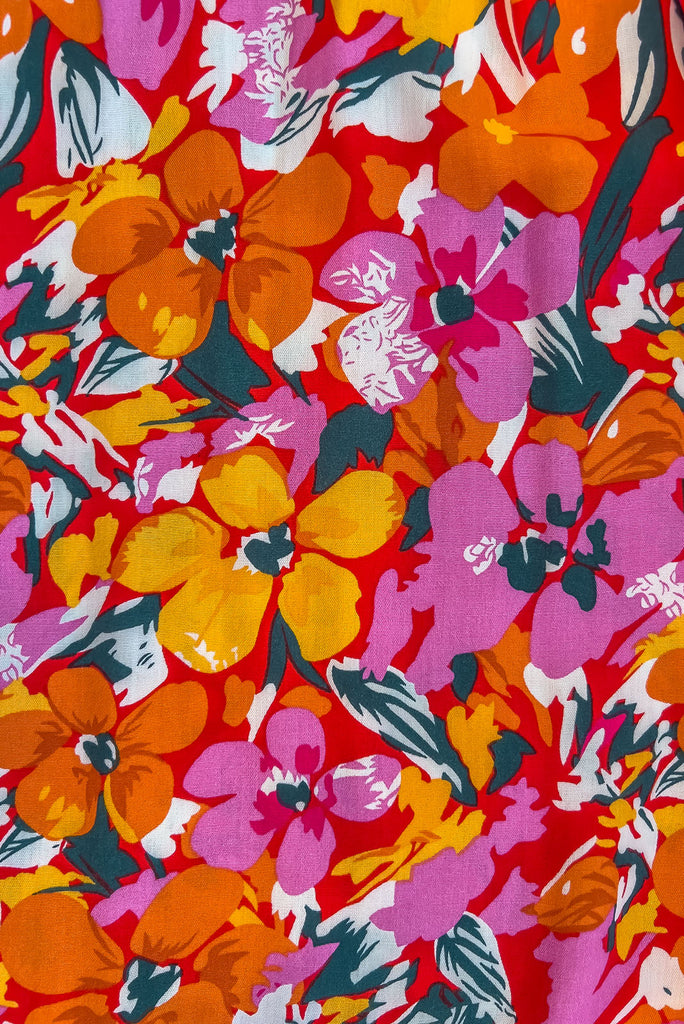 Our Nuance Top Features A High Neck With Gathering, Adjustable Neckline, Tie Back Keyhole, Shortened Front And An Airy Cut. The Viva L'Orange Print Is A Red Base With A Bright Pink, Orange, White And Green Botanical Print. 100% Rayon.