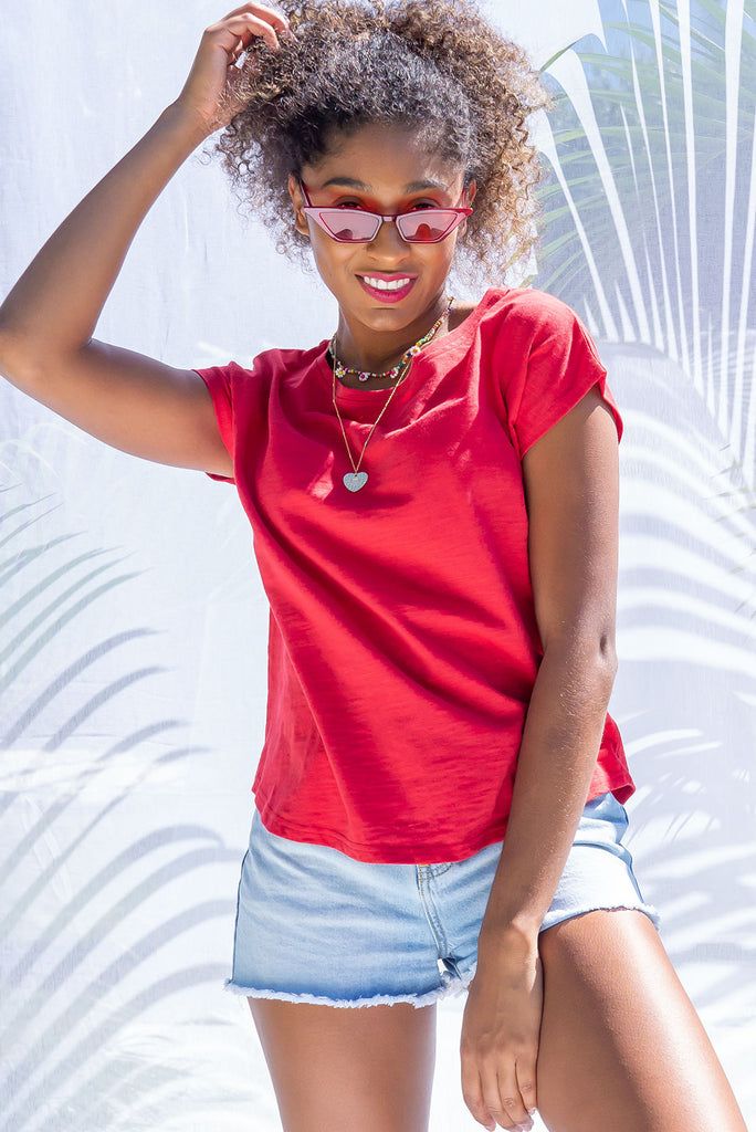 Our Classic Phoenix Tee In A Bold Red, Perfect For Pairing With Our Skirts. A Relaxed T-Shirt Fit, Soft Fabrication & Cap Sleeves. Wear Loose or Tied Up For A Cropped Look. 100% Cotton.
