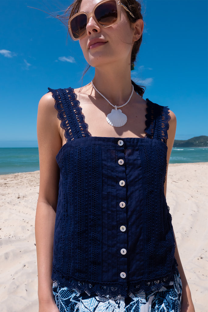 The Positano Navy Lace Cami Top is a beautiful navy coloured textured cami top with lace detailing on the straps, front and hem. The shirt also features a functional shell button front.