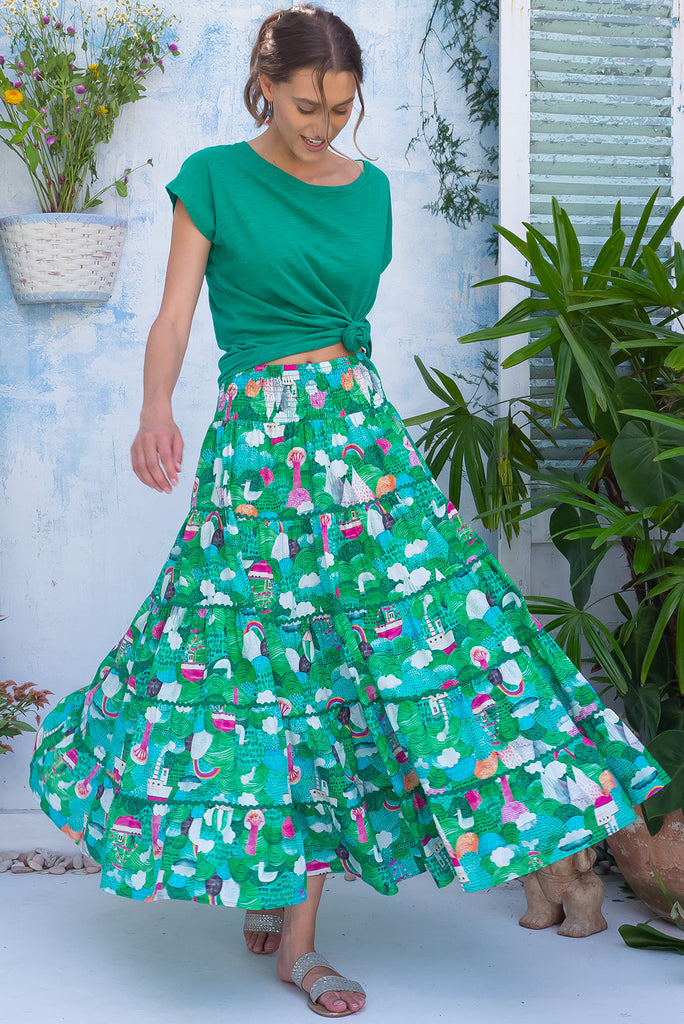 The Rozita Faraway Green Tiered Maxi Skirt is a gorgeous green based maxi skirt with an abstract tree print. The maxi skirt features side pockets, tiering, green ric-rac on each tier and an elasticated waistband. Made from 100% cotton.