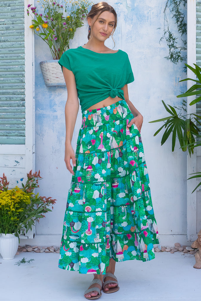 The Rozita Faraway Green Tiered Maxi Skirt is a gorgeous green based maxi skirt with an abstract tree print. The maxi skirt features side pockets, tiering, green ric-rac on each tier and an elasticated waistband. Made from 100% cotton.