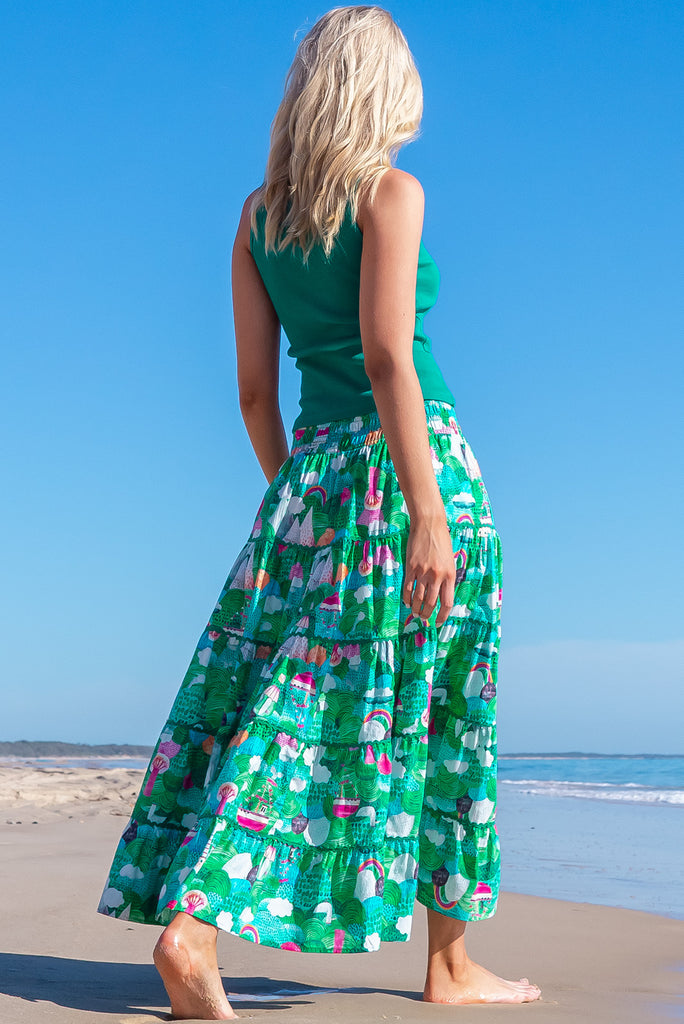The Rozita Faraway Green Tiered Maxi Skirt is a gorgeous green based maxi skirt with an abstract tree print. The maxi skirt features side pockets, tiering, green ric-rac on each tier and an elasticated waistband. Made from 100% cotton.