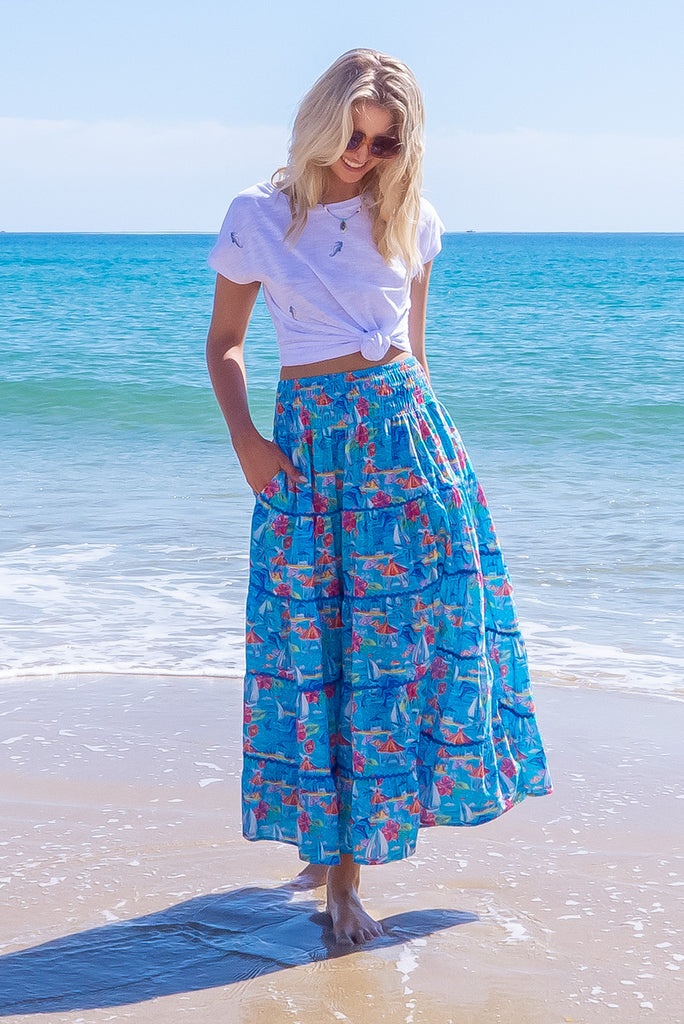 The Rozita Paradise Tiered Maxi Skirt is a gorgeous sky blue maxi skirt with a tropical floral and sailboat print all over. The maxi skirt features side pockets, tiering, blue ric-rac on each tier and an elasticated waistband. Made from 100% cotton.