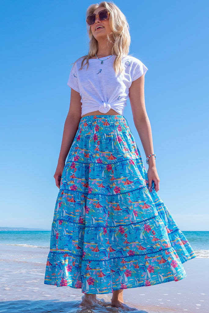 The Rozita Paradise Tiered Maxi Skirt is a gorgeous sky blue maxi skirt with a tropical floral and sailboat print all over. The maxi skirt features side pockets, tiering, blue ric-rac on each tier and an elasticated waistband. Made from 100% cotton.