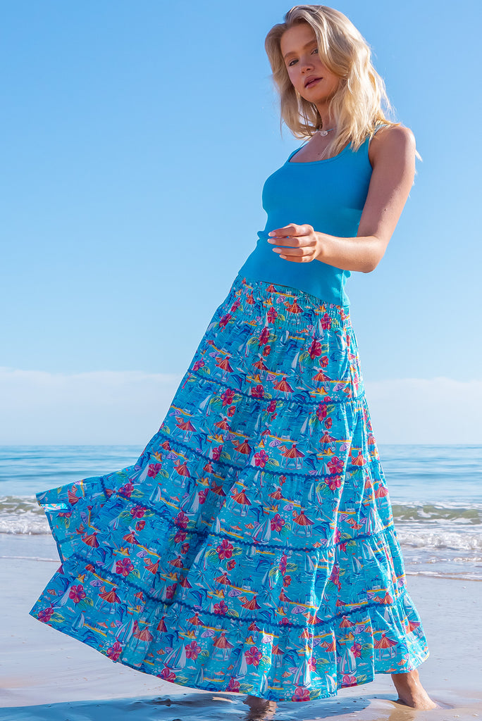The Rozita Paradise Tiered Maxi Skirt is a gorgeous sky blue maxi skirt with a tropical floral and sailboat print all over. The maxi skirt features side pockets, tiering, blue ric-rac on each tier and an elasticated waistband. Made from 100% cotton.