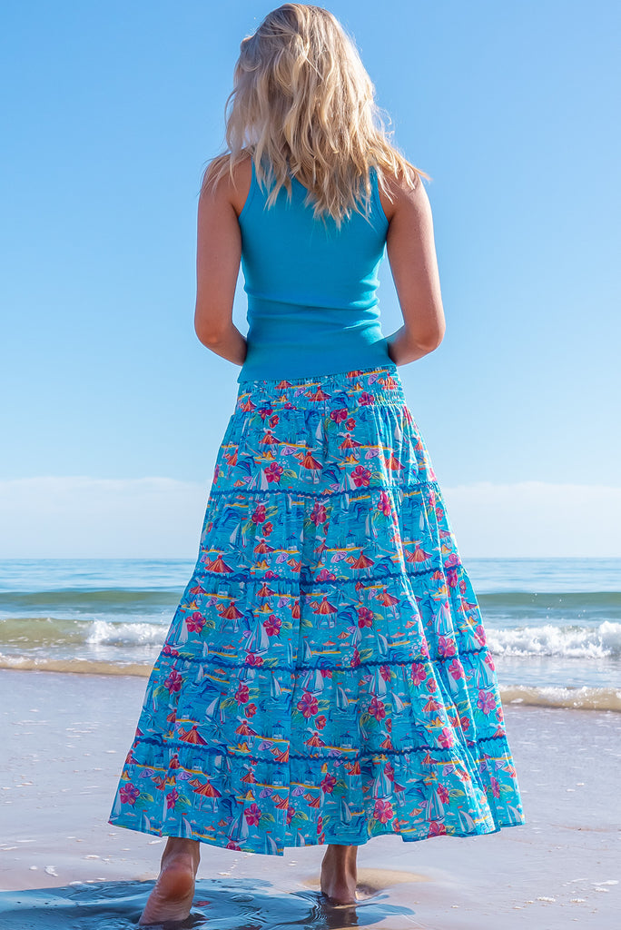 The Rozita Paradise Tiered Maxi Skirt is a gorgeous sky blue maxi skirt with a tropical floral and sailboat print all over. The maxi skirt features side pockets, tiering, blue ric-rac on each tier and an elasticated waistband. Made from 100% cotton.