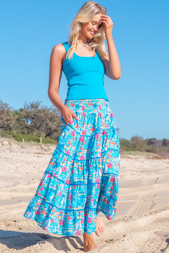 The Rozita Paradise Tiered Maxi Skirt is a gorgeous sky blue maxi skirt with a tropical floral and sailboat print all over. The maxi skirt features side pockets, tiering, blue ric-rac on each tier and an elasticated waistband. Made from 100% cotton.