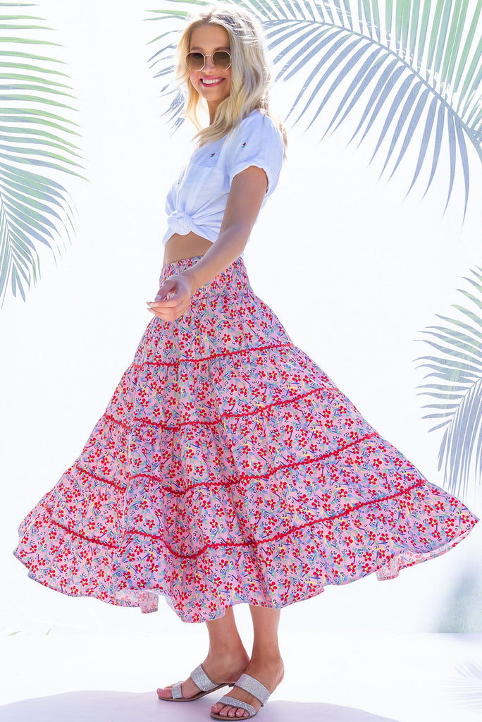 Swirl softly into the new season wearing the lovely Rozita Pink Tiered Maxi Skirt. Airy and sweet, this gorgeous separate will see you through spring and summer in effortless style and complete comfort. Cotton, shirred waistband, pockets, pink floral print and red ric-rac feature.