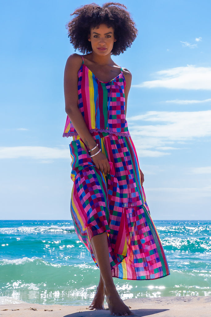 The Valencia Carnivale Maxi Skirt is a vibrant and fun skirt featuring elasticated waistband with decorative tie, side pockets and Woven fabric 95% cotton 5% polyester in vibrant multi coloured check and stripe print with a lurex thread running through.